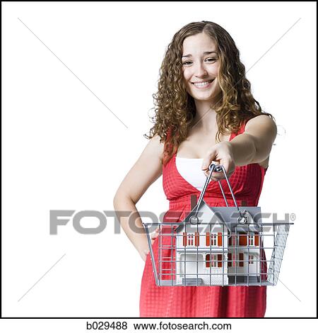 person holding a miniature house in a shopping basket View Large Photo Image Stock Photo - person holding a miniature house in a shopping basket. Fotosearch