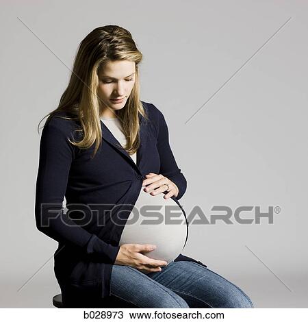 Stock Image - pregnant woman touching her belly. Fotosearch