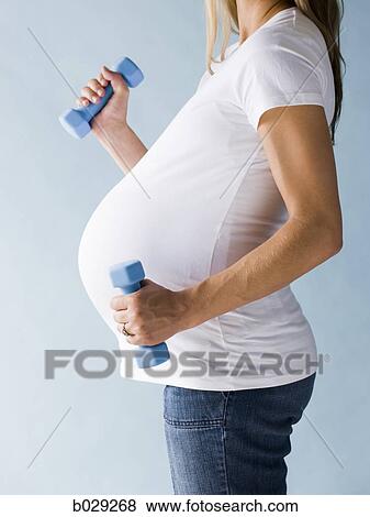Stock Photo - pregnant woman working out. Fotosearch