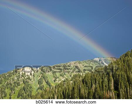 Picture - rainbow over a mountain range. Fotosearch