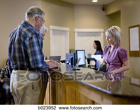 receptionist talking to patients at a doctor's office View Large Photo Image Stock Image - receptionist talking to patients at a doctor's office. Fotosearch