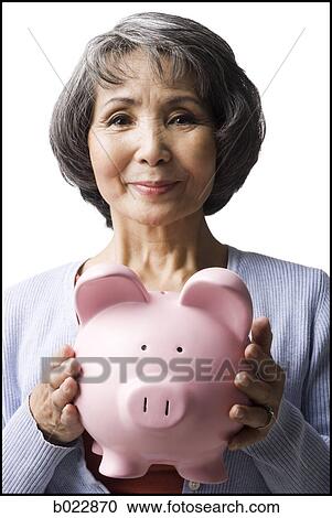 senior woman holding a piggy bank View Large Photo Image Stock Image - senior woman holding a piggy bank. Fotosearch