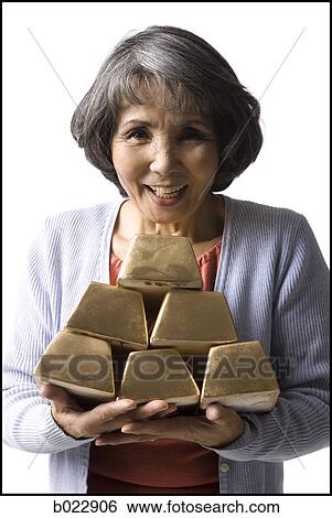senior woman holding a stack of gold bricks View Large Photo Image Stock Photograph - senior woman holding a stack of gold bricks. Fotosearch