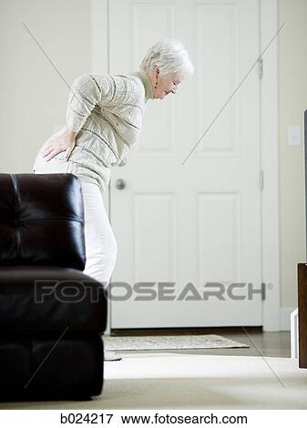 Stock Photo - senior woman holding back. Fotosearch