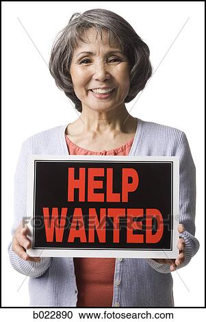 Stock Image - senior woman holding help wanted sign. Fotosearch