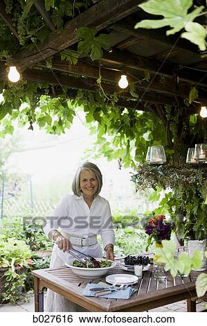 Stock Photograph - senior woman preparing food outdoors. Fotosearch