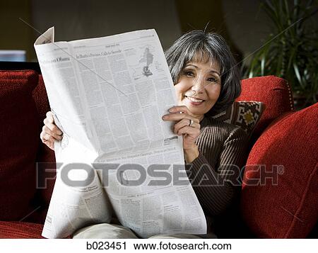 senior woman reading a newspaper on the couch View Large Photo Image Stock Image - senior woman reading a newspaper on the couch. Fotosearch