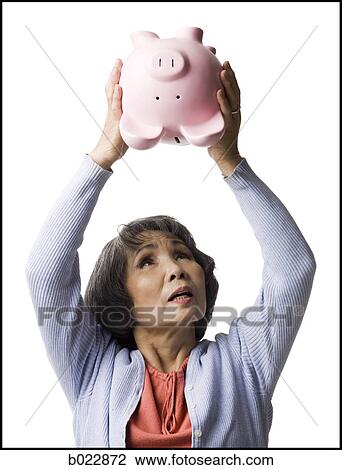 senior woman shaking piggy bank View Large Photo Image Stock Image - senior woman shaking piggy bank. Fotosearch