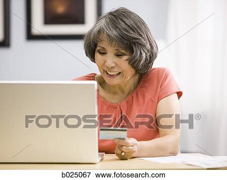 Stock Photo - senior woman shopping online. Fotosearch
