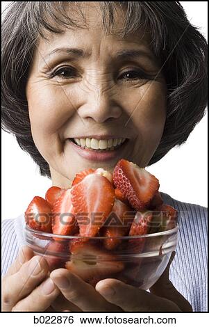 Stock Photograph - senior woman with a bowl of strawberries. Fotosearch