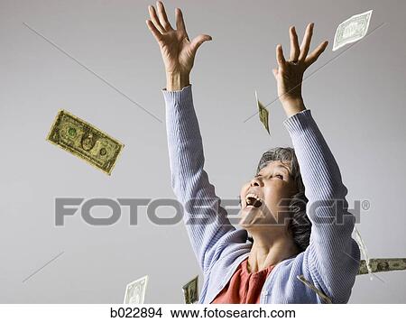 senior woman with money falling around her View Large Photo Image Picture - senior woman with money falling around her. Fotosearch
