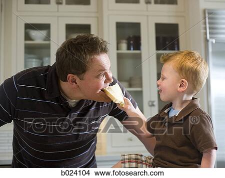 son feeding his father a piece of bread View Large Photo Image Picture - son feeding his father a piece of bread. Fotosearch