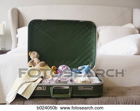 suitcase sitting open on a bed View Large Photo Image Stock Image - suitcase sitting open on a bed. Fotosearch