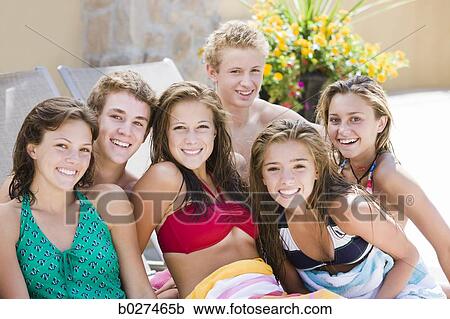 Stock Image - teenagers lounging poolside. Fotosearch