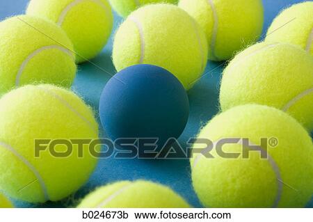 Stock Image - tennis balls and a racquetball against a blue background. Fotosearch