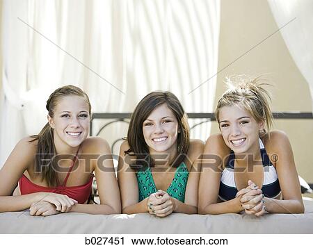 Stock Image - three teenage girls lying in a cabana. Fotosearch