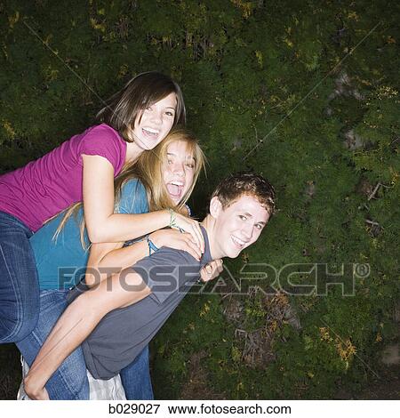 Stock Photo - three teenagers climbing on each other. Fotosearch