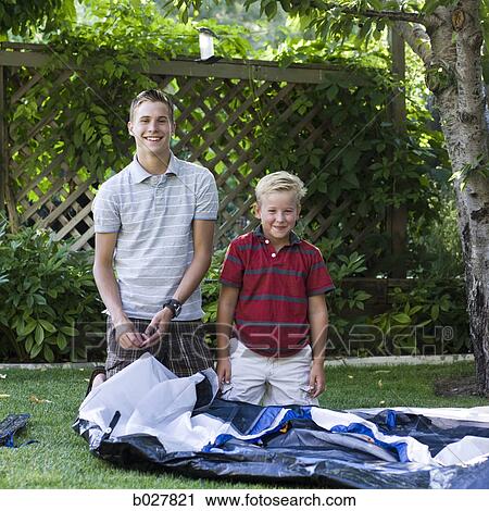 two brothers putting up a tent in their backyard View Large Photo Image Stock Image - two brothers putting up a tent in their backyard. Fotosearch