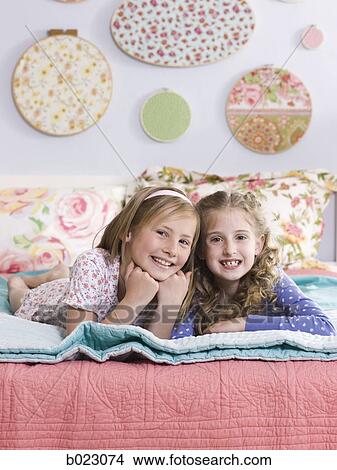 two girls on a bed View Large Photo Image Picture - two girls on a bed. Fotosearch