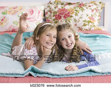 two girls on a bed View Large Photo Image Stock Photograph - two girls on a bed. Fotosearch