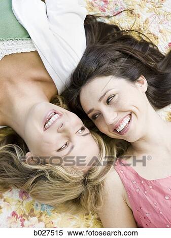 two women lying down on a floral print blanket outside View Large Photo Image Stock Photography - two women lying down on a floral print blanket outside. Fotosearch