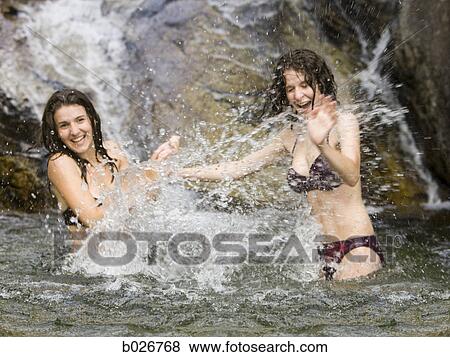 two women splashing in a mountain pool View Large Photo Image Stock Photo - two women splashing in a mountain pool. Fotosearch