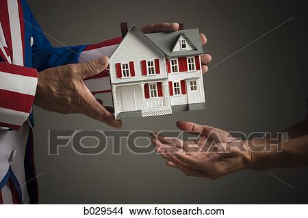 uncle sam taking a miniature house View Large Photo Image Picture - uncle sam taking a miniature house. Fotosearch