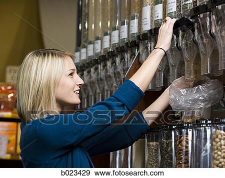 Stock Photo - woman buying nuts at the supermarket. Fotosearch