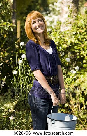 woman carrying a bucket in the garden View Large Photo Image Stock Photograph - woman carrying a bucket in the garden. Fotosearch