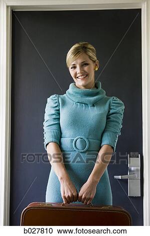 woman carrying a suitcase outside a door View Large Photo Image Stock Image - woman carrying a suitcase outside a door. Fotosearch
