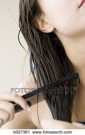 Stock Image - woman combing her hair. Fotosearch