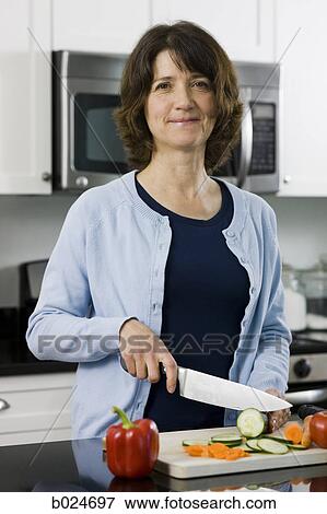 woman cutting vegetables in a kitchen View Large Photo Image Stock Photo - woman cutting vegetables in a kitchen. Fotosearch