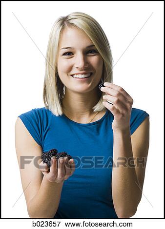 Stock Photo - woman eating blackberries. Fotosearch