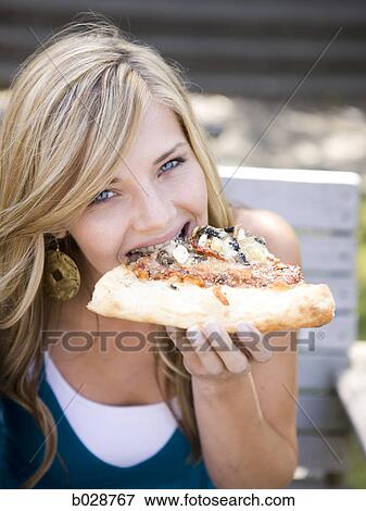 woman eating pizza while looking at camera and smiling View Large Photo Image Stock Photo - woman eating pizza while looking at camera and smiling. Fotosearch