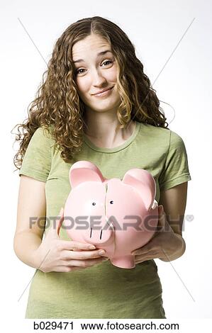 Stock Image - woman holding a broken piggy bank. Fotosearch