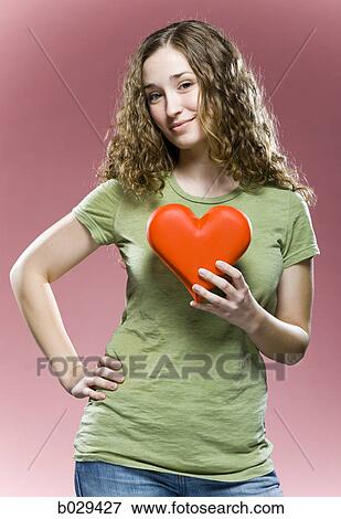 woman holding a heart to her chest View Large Photo Image Stock Photo - woman holding a heart to her chest. Fotosearch