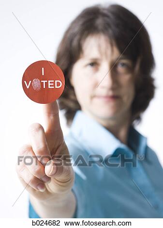 Stock Image - woman holding a "I voted" sticker. Fotosearch