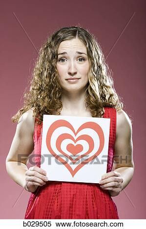 woman holding a red heart over her chest View Large Photo Image Stock Photography - woman holding a red heart over her chest. Fotosearch