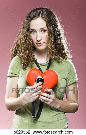 woman holding a stethoscope up to her heart View Large Photo Image Stock Image - woman holding a stethoscope up to her heart. Fotosearch