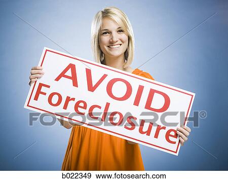 Stock Photo - woman holding an "avoid forclosure" sign. Fotosearch