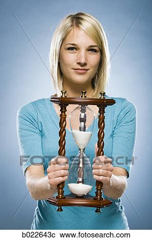 Stock Image - woman holding an hourglass. Fotosearch