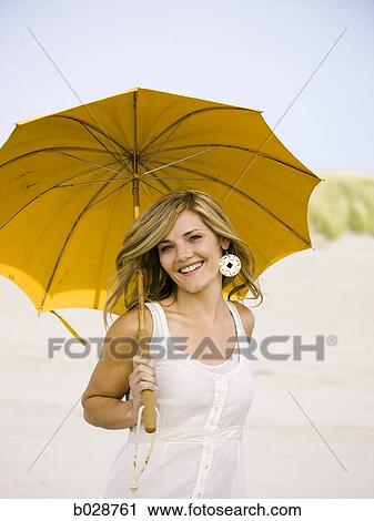 woman holding an umbrella at the beach View Large Photo Image Stock Image - woman holding an umbrella at the beach. Fotosearch