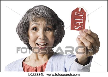 Stock Image - woman holding "sale" tag. Fotosearch