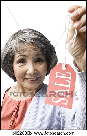 Stock Image - woman holding "sale" tag. Fotosearch