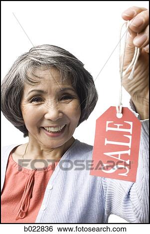 Stock Photograph - woman holding "sale" tag. Fotosearch