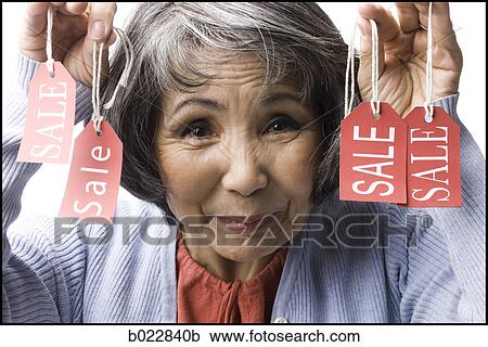 Stock Image - woman holding "sale" tags. Fotosearch