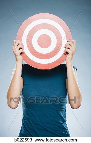 Stock Image - woman holding up a target. Fotosearch