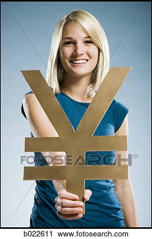 Stock Image - woman holding up a yen symbol. Fotosearch