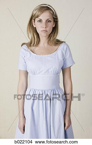 Picture - woman in a blue dress with a straight face. Fotosearch