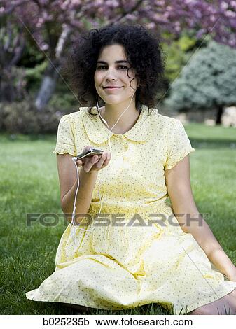 woman in a yellow dress listening to music View Large Photo Image Stock Image - woman in a yellow dress listening to music. Fotosearch